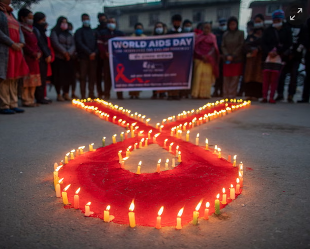 Phụ nữ và trẻ em thắp nến tạo thành biểu tượng Ruy băng đỏ ở Kathmandu, Nepal, vào Ngày Thế giới phòng chống AIDS. Ảnh: Narendra Shrestha / EPA