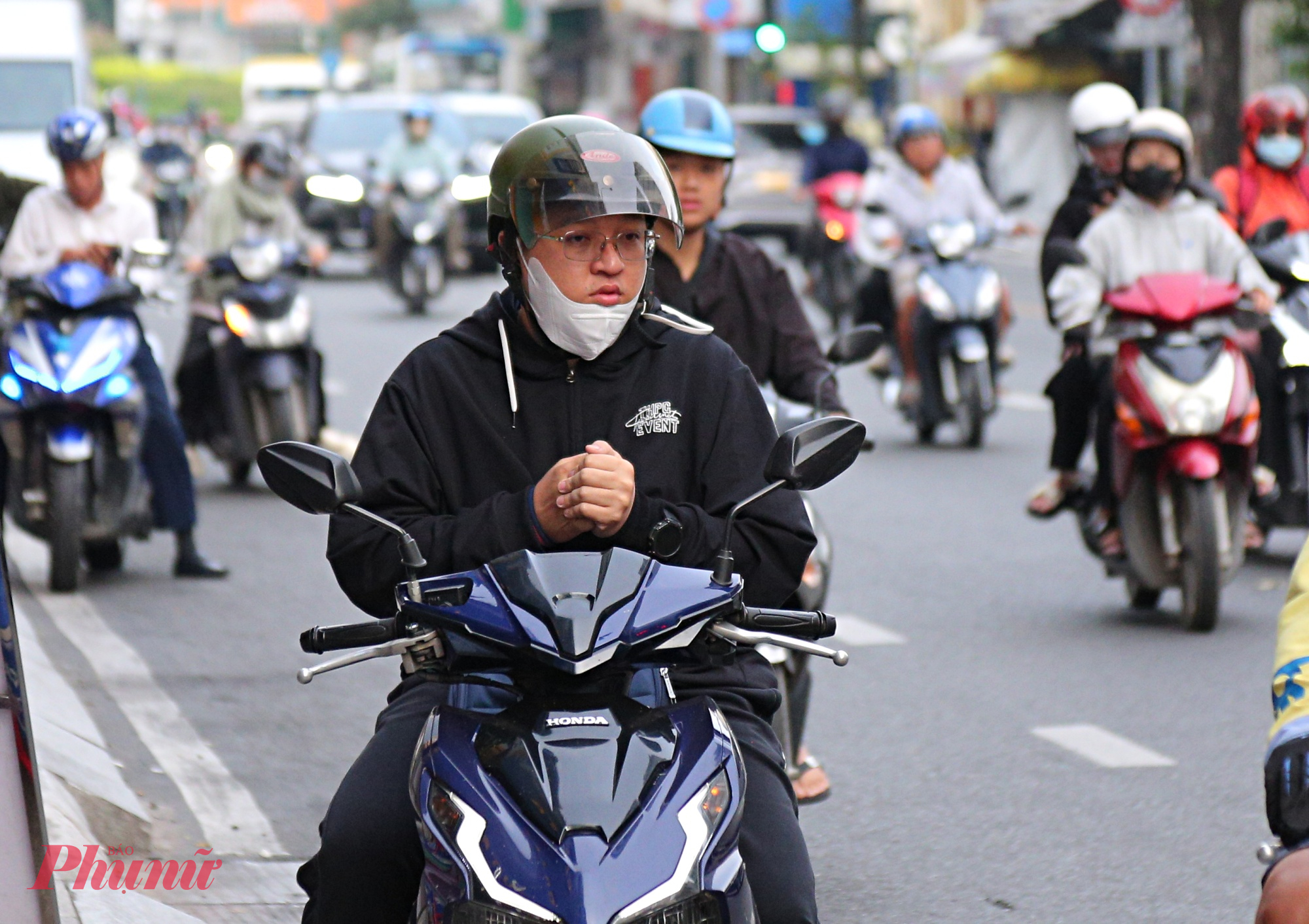 Nam thanh niên xoa tay để giữ ấm trong lúc dừng chờ mua hàng