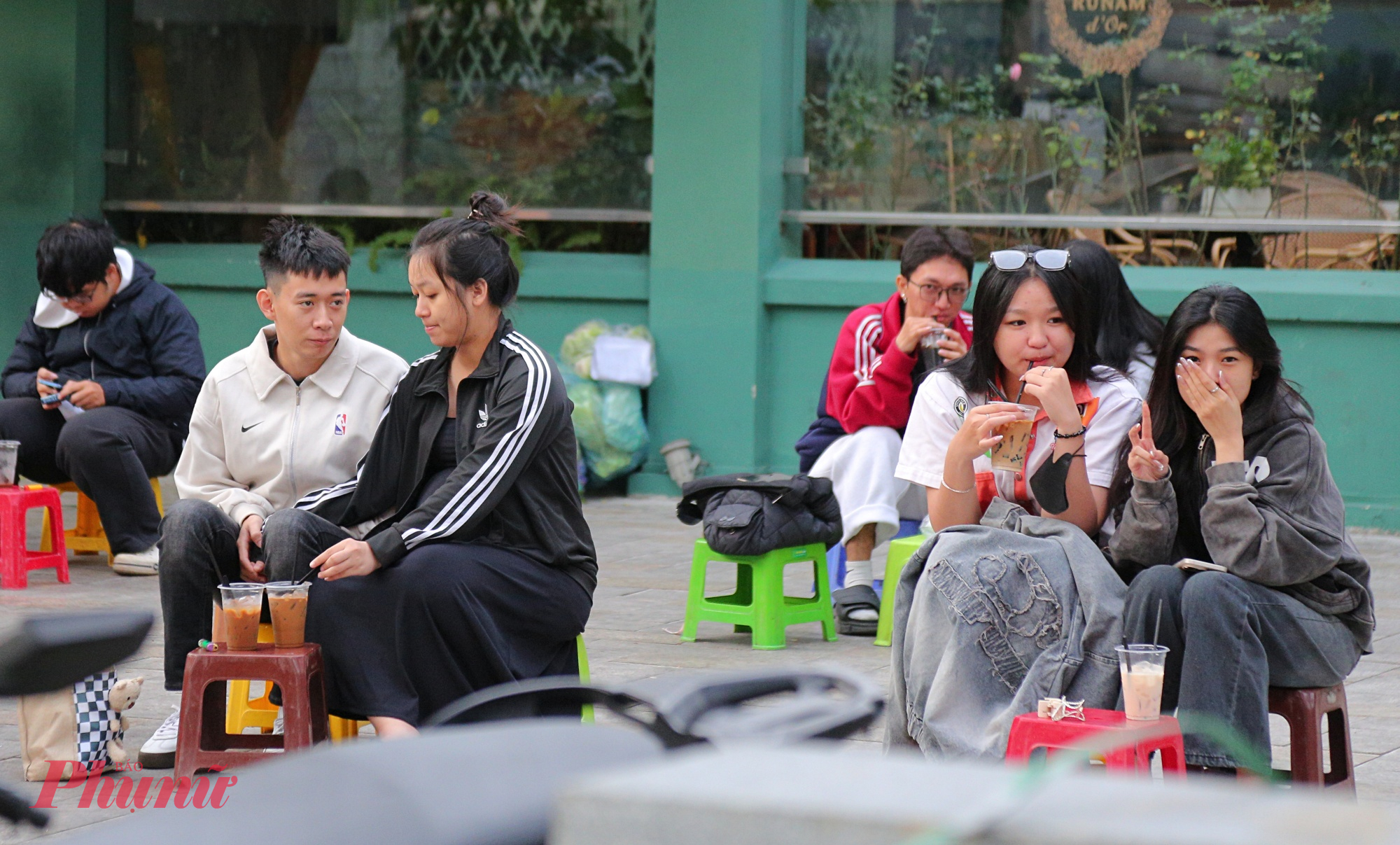 Nhiều bạn trẻ đi cà phê vỉa hè tại gần Nhà thờ Đức Bà cảm nhận được không khí se lạnh, nên láy áo khóa che 