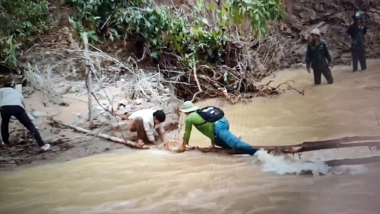 Người dân thôn Phú Đồng, Phú Hải, xã vùng cao Phú Mỡ bò trên cầu tạm đi nhận quà cứu trợ--Ảnh: MHN