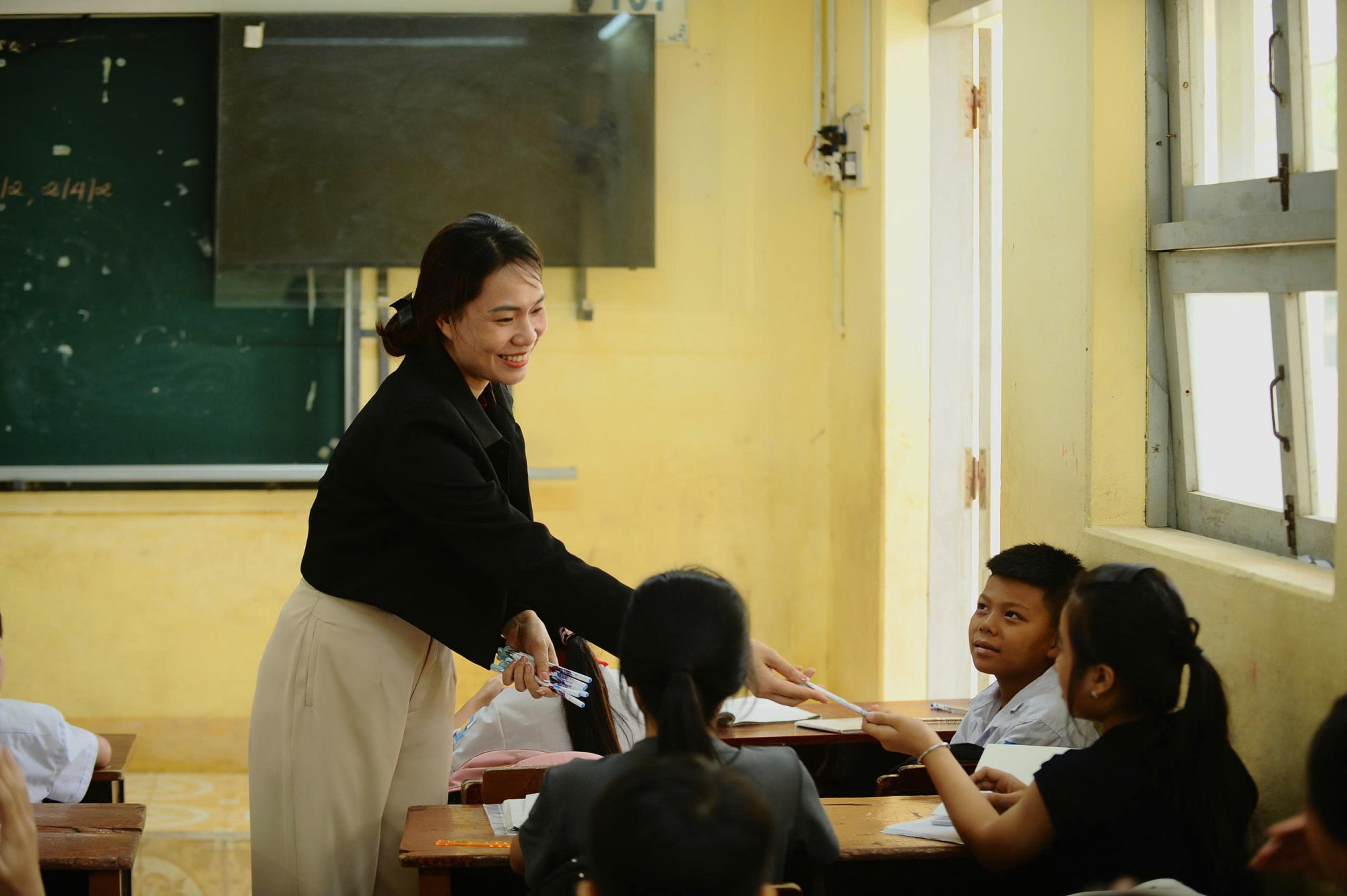 Hiểu được khó khăn của học trò, trong buổi học đầu tiên, các thầy cô dành nhiều thời gian hơn để động viên, hỏi han. Một cô giáo nhẹ nhàng trao từng cây bút cho học sinh – những món quà nhỏ nhưng chứa đựng sự sẻ chia lớn lao.