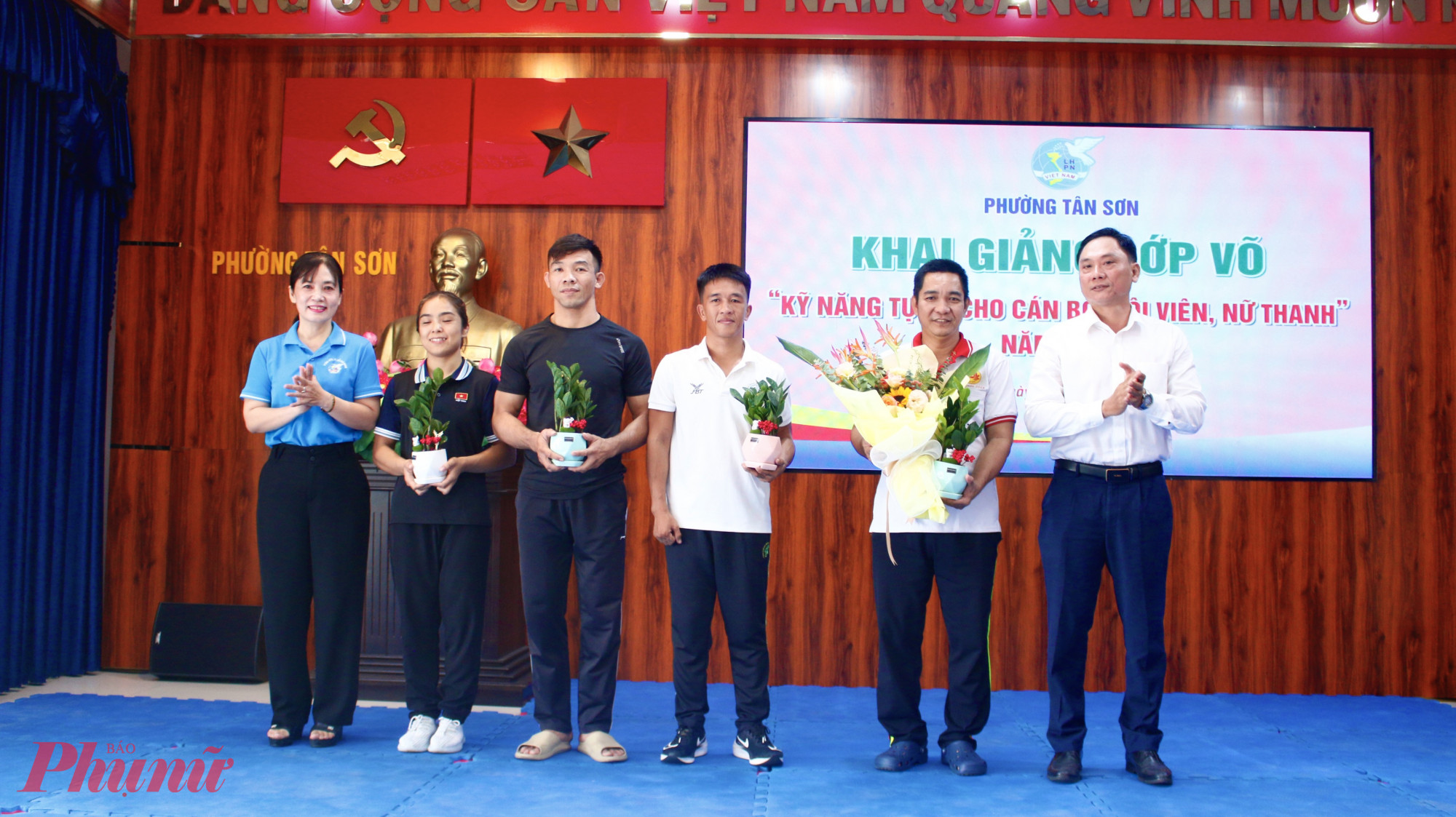 Ông Nguyễn Xuân Tiến - Bí thư Đảng ủy phường Tân Sơn (bìa phải) và bà Nguyễn Thị Kim Thanh – Chủ tịch Hội LHPN phường Tân Sơn trao hoa và cây xanh đến đội ngũ HLV giảng dạy 