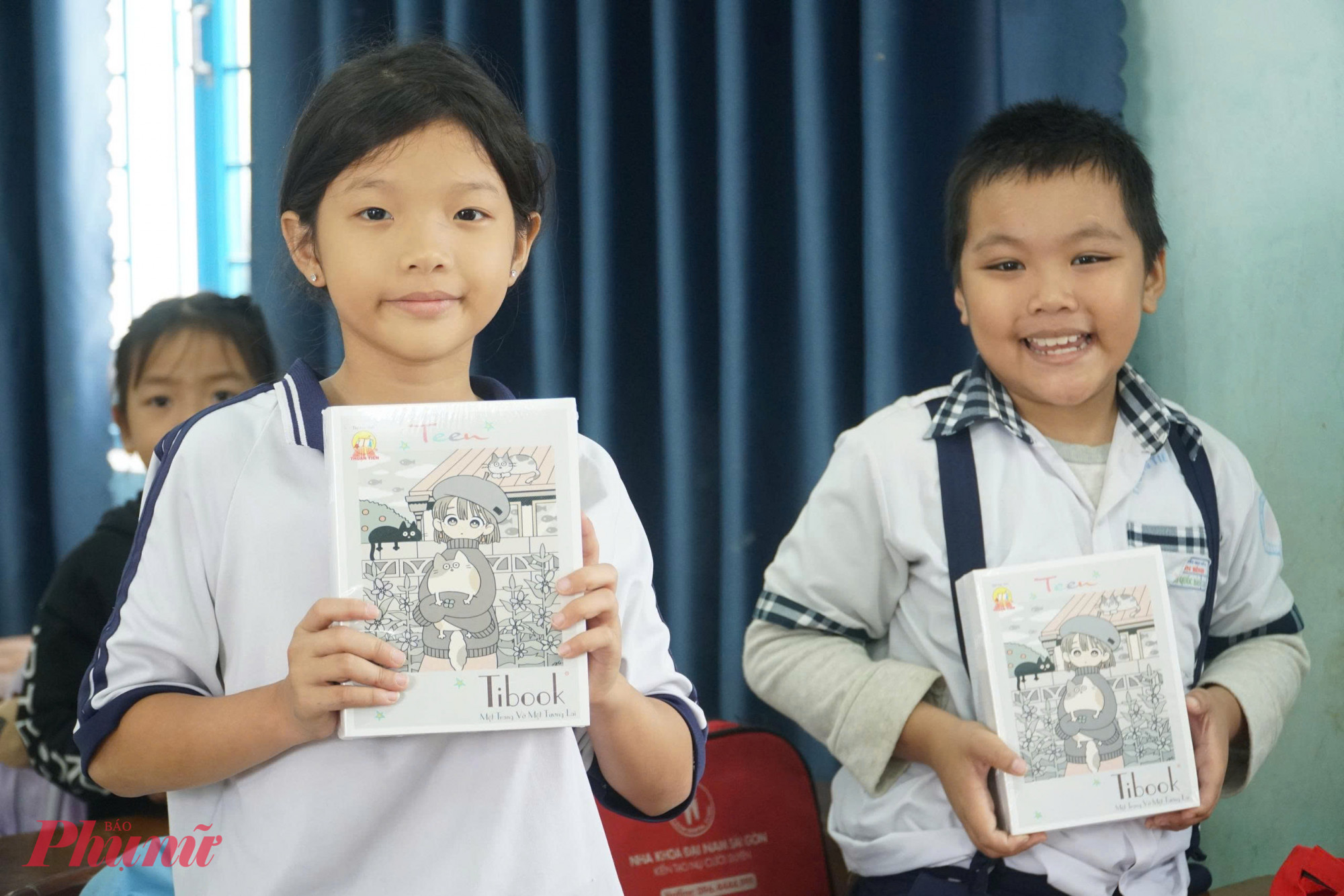 Học sinh trường tiểu học số 2 Nhơn Bình, phường Quy Nhơn Tây vui mừng nhận vở mới để sớm đến trường sau lũ.