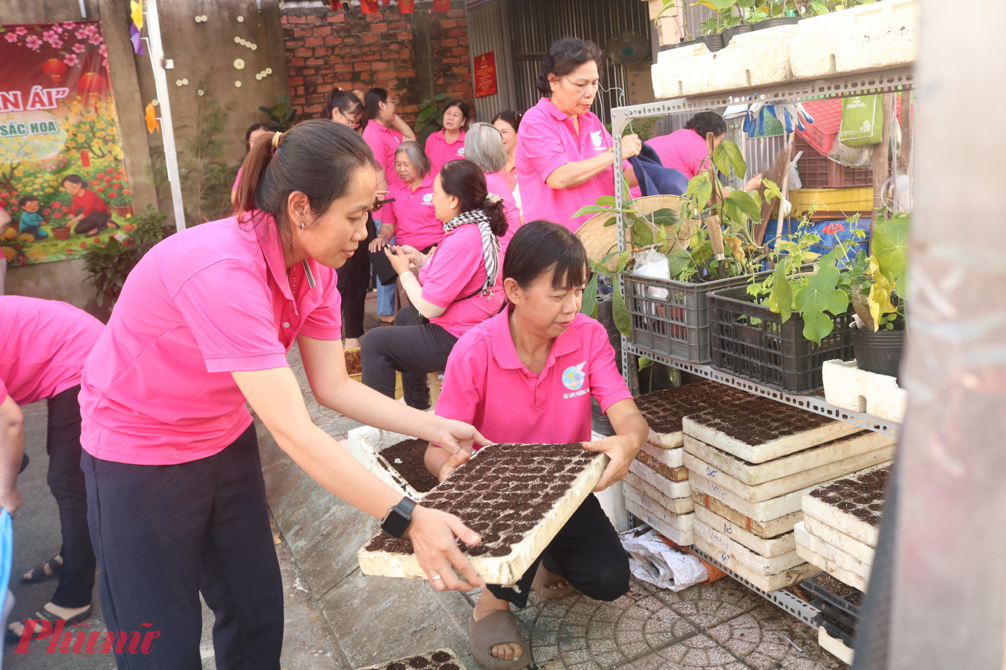 Chị Trần Thị Hoài Biên (bìa phải) là người phụ trách chính việc chăm sóc vườn hoa - Ảnh: Mẫn Nhi
