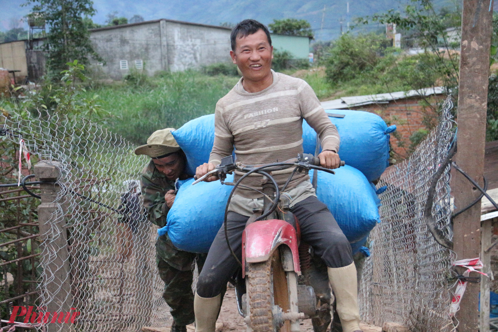 Nụ cười rạng rỡ của người dân khi chở nông sản vượt qua cầu tạm. 