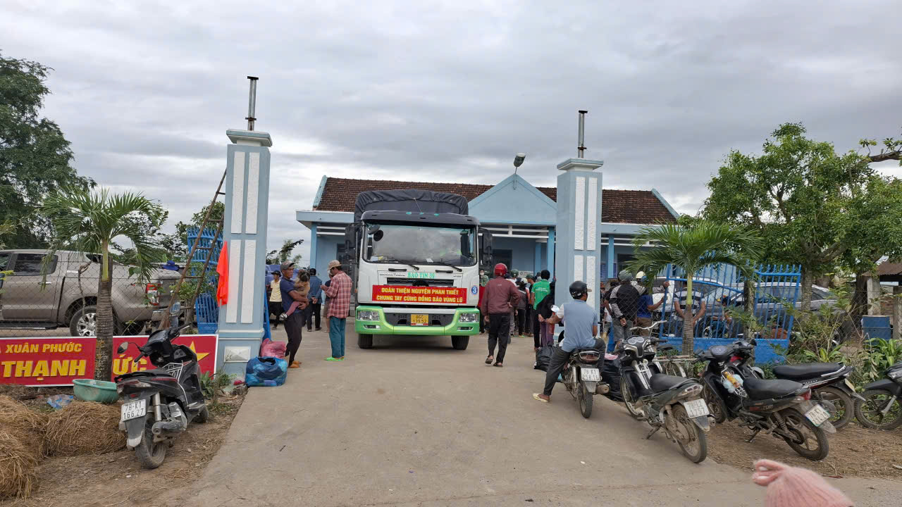 Người dân phơi rơm ướt trước cổng trụ sở thôn Thạnh Đức, xã Xuân Phước có đoàn phát quà cứu trợ- Ảnh: Mạnh Hoài Nam