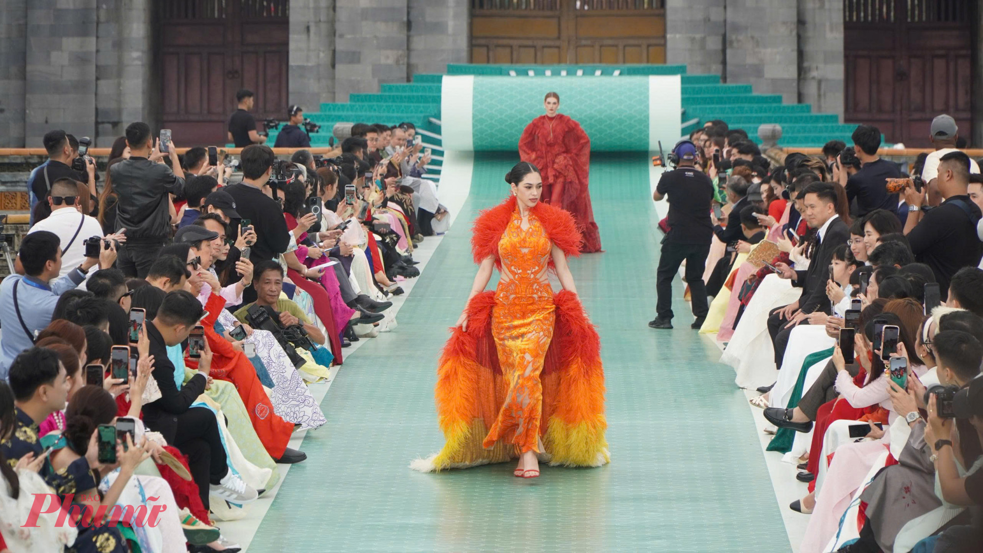 những kỹ thuật draping mềm mại, thêu tay tinh xảo, xử lý chất liệu hiện đại, và bảng màu trầm mặc: vàng son, đỏ ngọc, xanh rêu, nâu gỗ, ánh ngọc trai và đen huyền