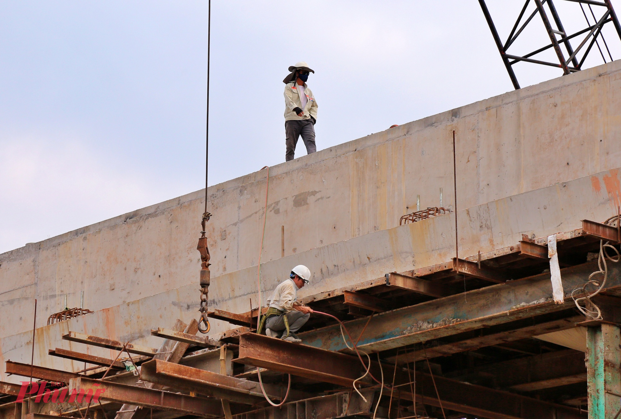 Công nhân đang thi công hoàn thiện hành lan cầu cạn. Theo Ban Giao thông TPHCM (chủ đầu tư), dự kiến thông tuyến chính vào cuối năm 2025 và hoàn thành toàn bộ dự án vào giữa năm 2026.