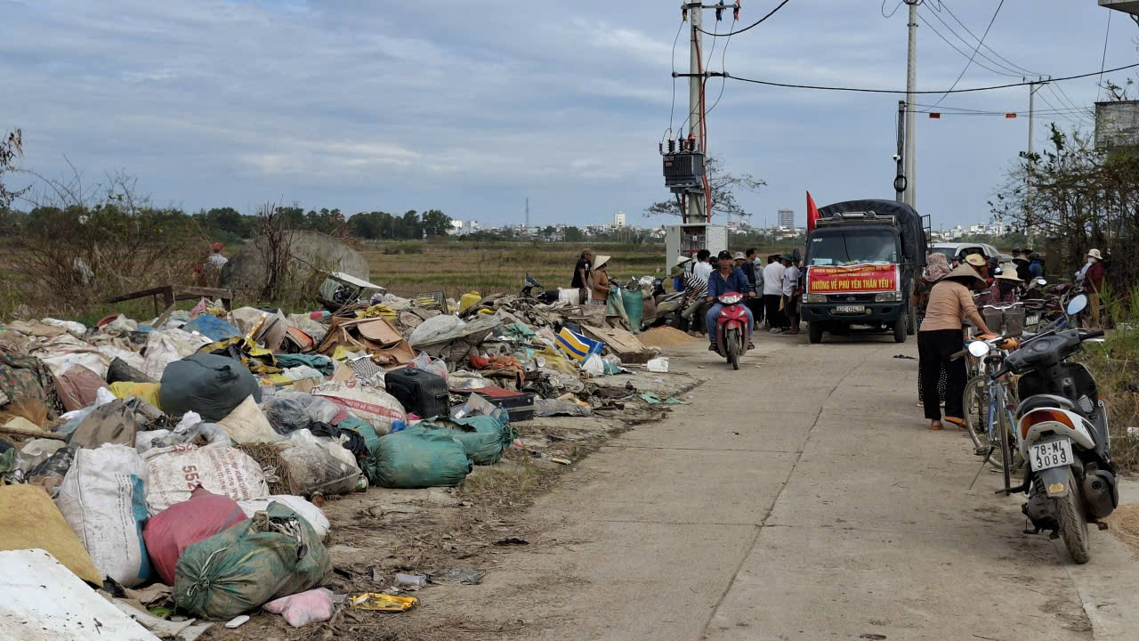 Rác đầy đường, không còn chỗ trống, đoàn thiện nguyện đến phát quà cứu trợ cạnh đống rác- Ảnh: Mạnh Trâm Trân 