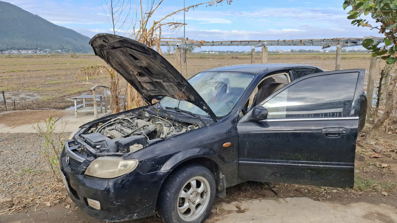 Thân xác” của chiếc xe ô tô bị lũ dữ ngâm nhiều ngày đem phơi nắng- Ảnh: Mạnh Trâm Trân 