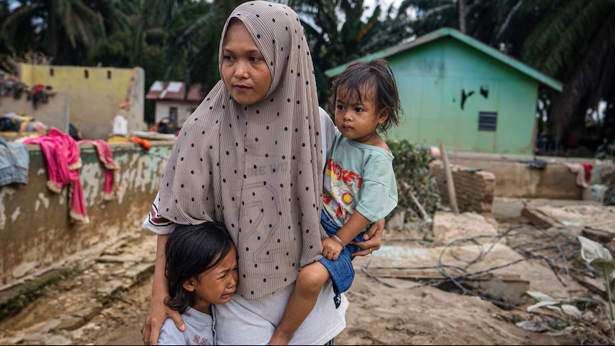 Siti Nurbaya Siregar - một cư dân tại Langkat Regency - và hai con của cô sống sót nhờ được sơ tán bằng thuyền - Ảnh: ABC News/Tim Swanston)