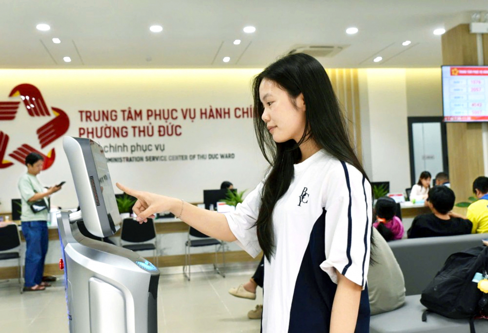 Người dân làm thủ tục tại Trung tâm Phục vụ hành chính công phường Thủ Đức với sự hỗ trợ của robot