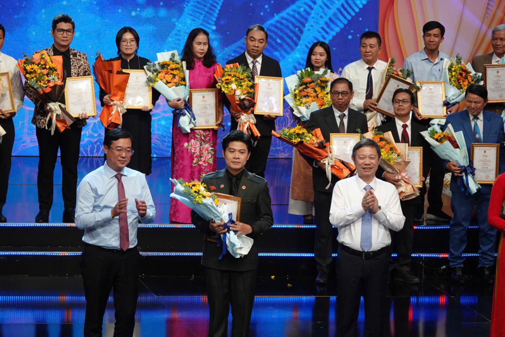 Phó Bí thư thường trực Thành ủy TPHCM Lê Quốc Phong và Trưởng Ban Tuyên giáo và Dân vận Thành ủy TPHCM Dương Anh Đức trao giải cho nhạc sĩ Nguyễn Văn Chung - Ảnh: Mạnh Hảo.
