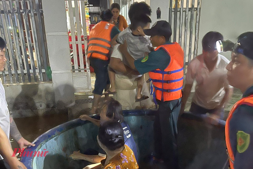 Lực lượng Dân quân tự vệ dùng thúng di chuyển người dân ra khỏi khu vực có nguy cơ bị ngập sâu.