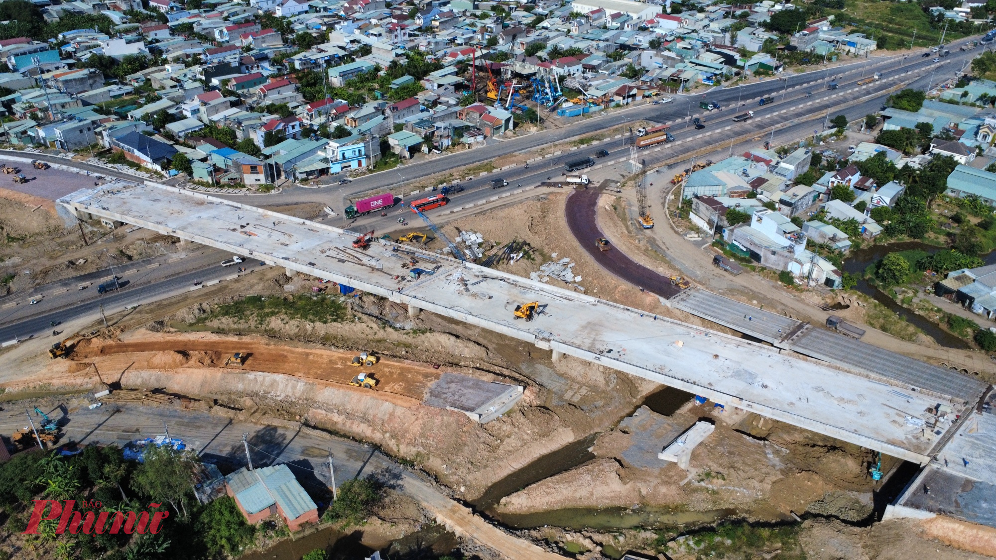 Cầu vượt qua giao lộ Võ Nguyên Giáp đã hợp long, đang triển khai thi công thảm nhựa từ đường dẫn lên mặt cầu.
