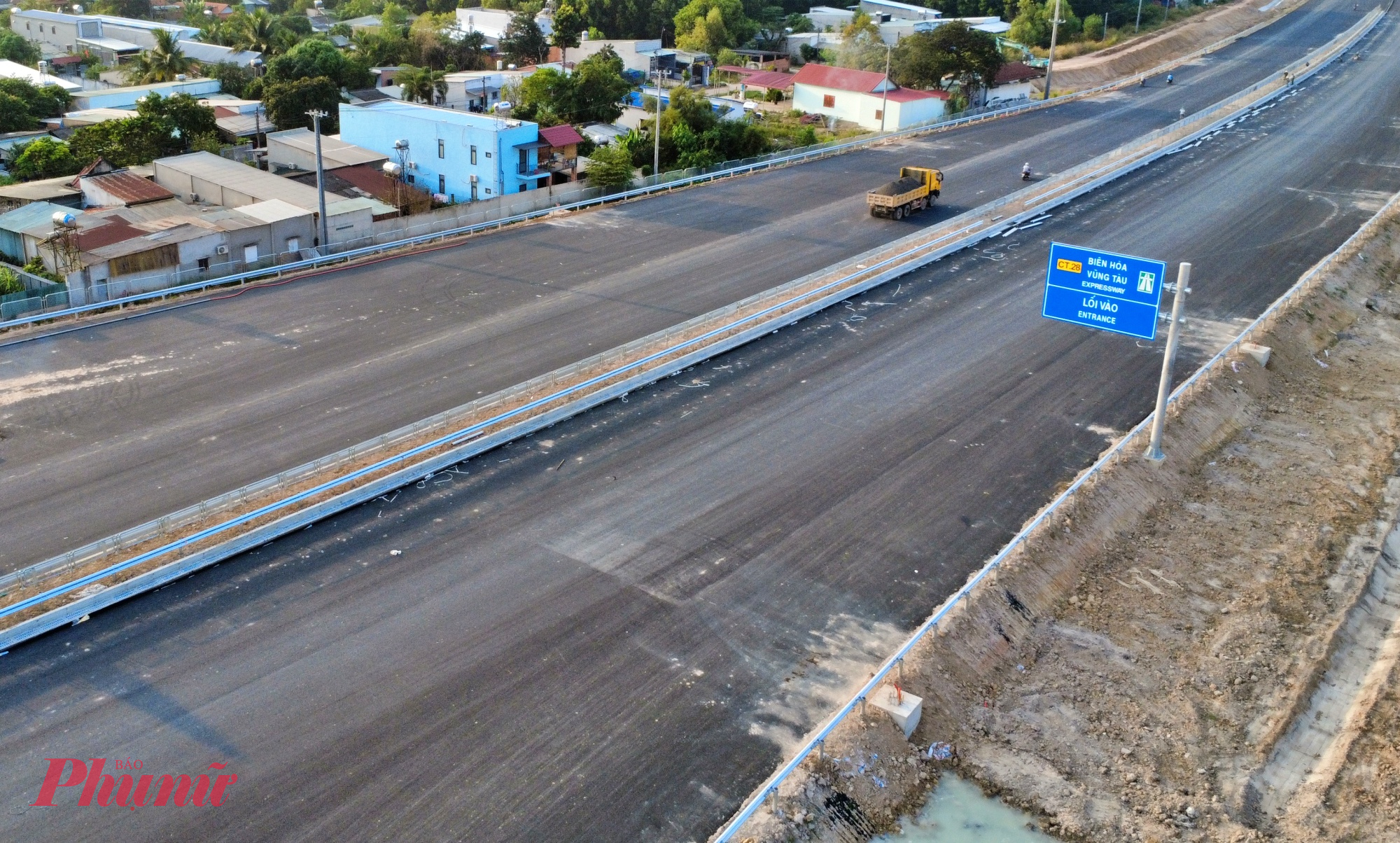 Tại vị trí giáp ranh Đồng Nai - TPHCM (xã Phước Thái), mặt đường đã được thảm nhựa. Song song với thảm nhựa, các hạng mục gia cố bê tông xi măng, cấp phối đá dăm, lắp đặt dải phân cách cứng và hàng rào bảo vệ cũng đang được triển khai đồng loạt. 