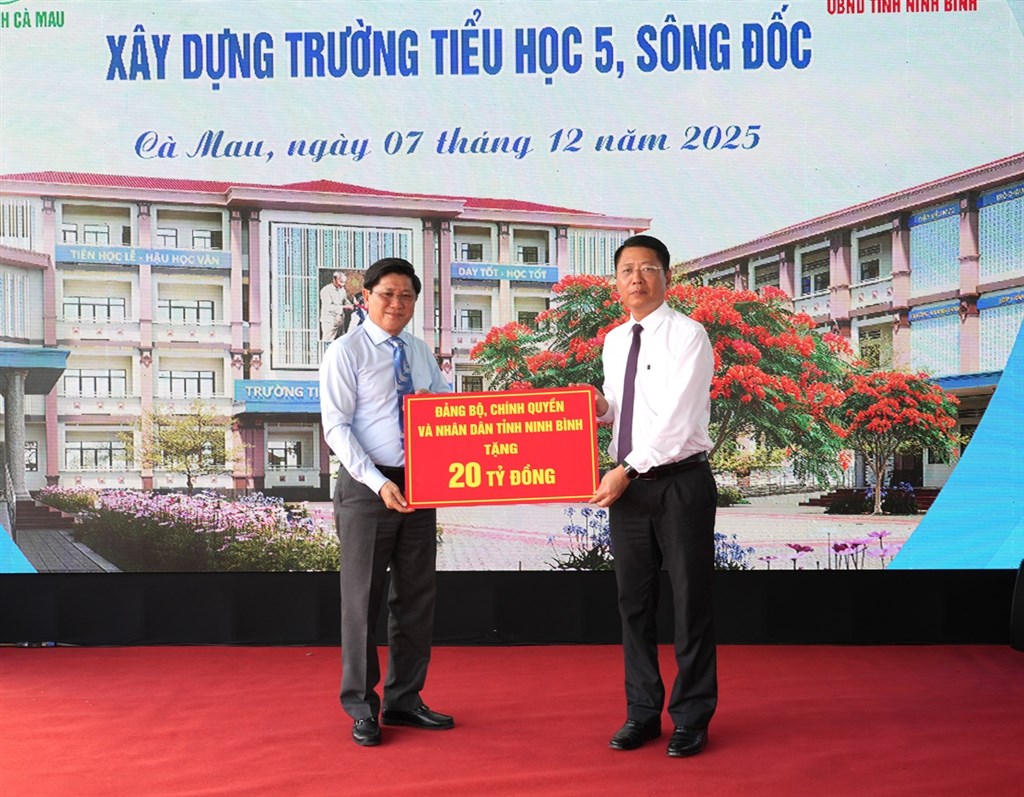 Phó Chủ tịch UBND tỉnh Lê Văn Sử (bên trái) nhận bảng tượng trưng 20 tỉ đồng từ lãnh đạo tỉnh Ninh Bình.