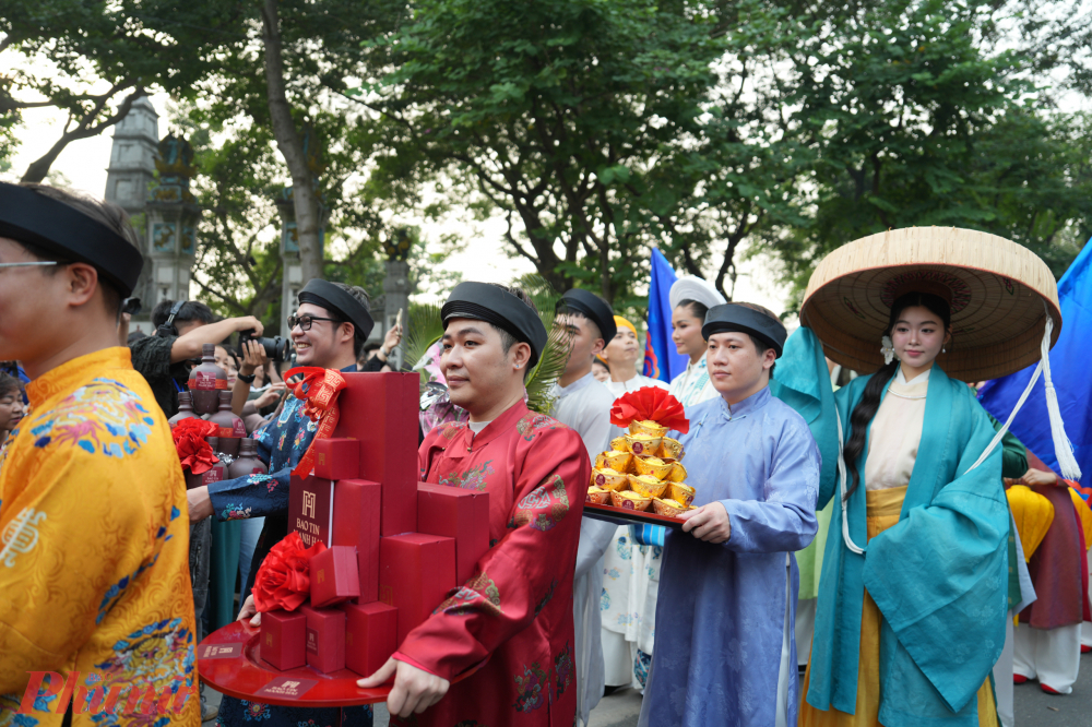 Các thành viên đoàn rước, trong đó có đội hình nữ quan, diện áo dài, nhật bình, ngũ thân rực rỡ, diễu hành trang nghiêm theo đúng nghi thức truyền thống, làm nổi bật vẻ đẹp của trang phục cung đình.
