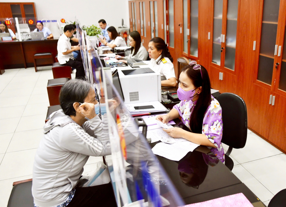 Cán bộ UBND phường Xóm Chiếu hướng dẫn người dân làm thủ tục hành chính 