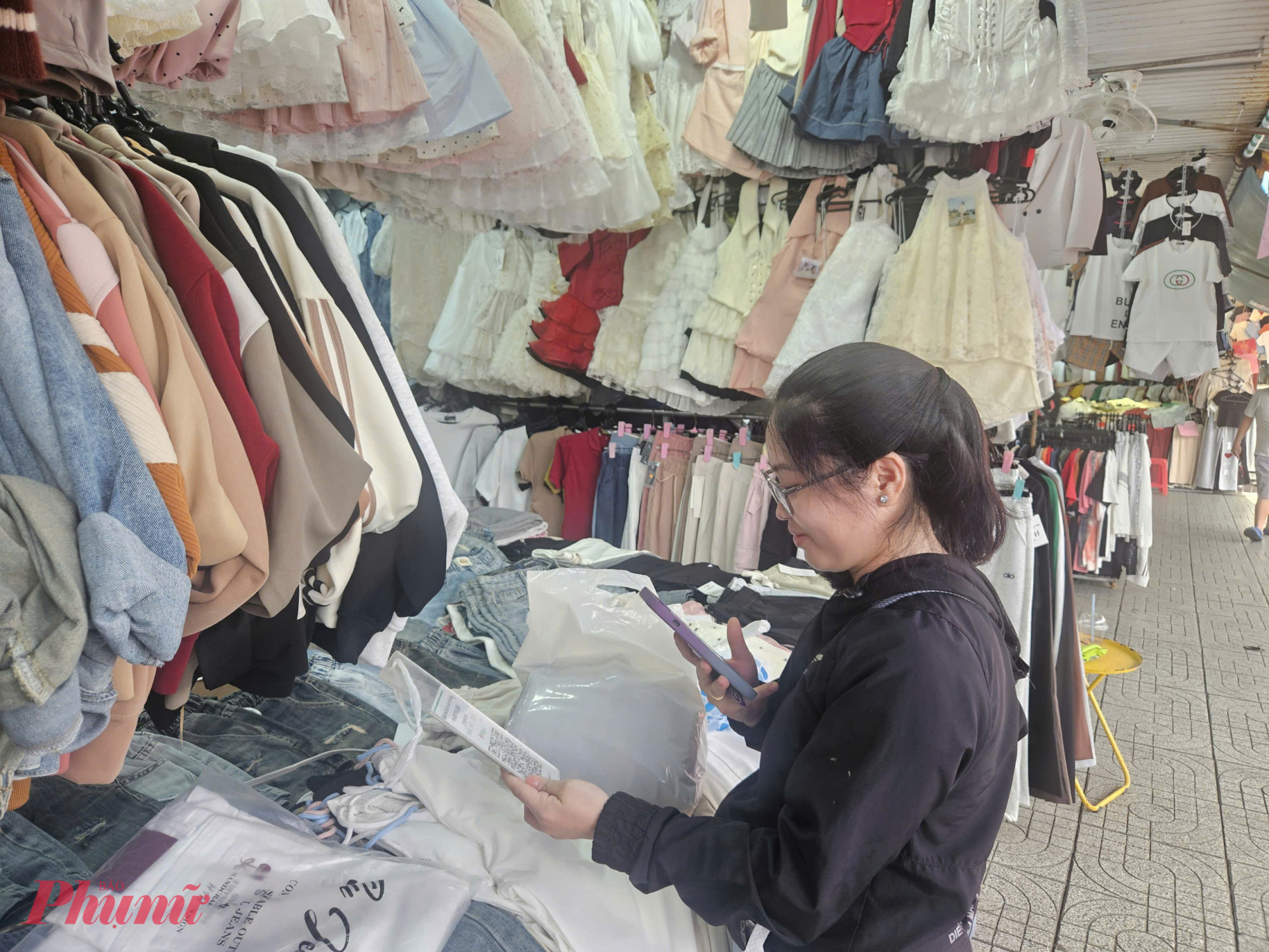 Người mua sắm tại chợ Phạm Văn Hai thanh toán bằng mã QR — hình thức đang được khuyến khích song song với chương trình giảm giá trong Shopping Season 2025.