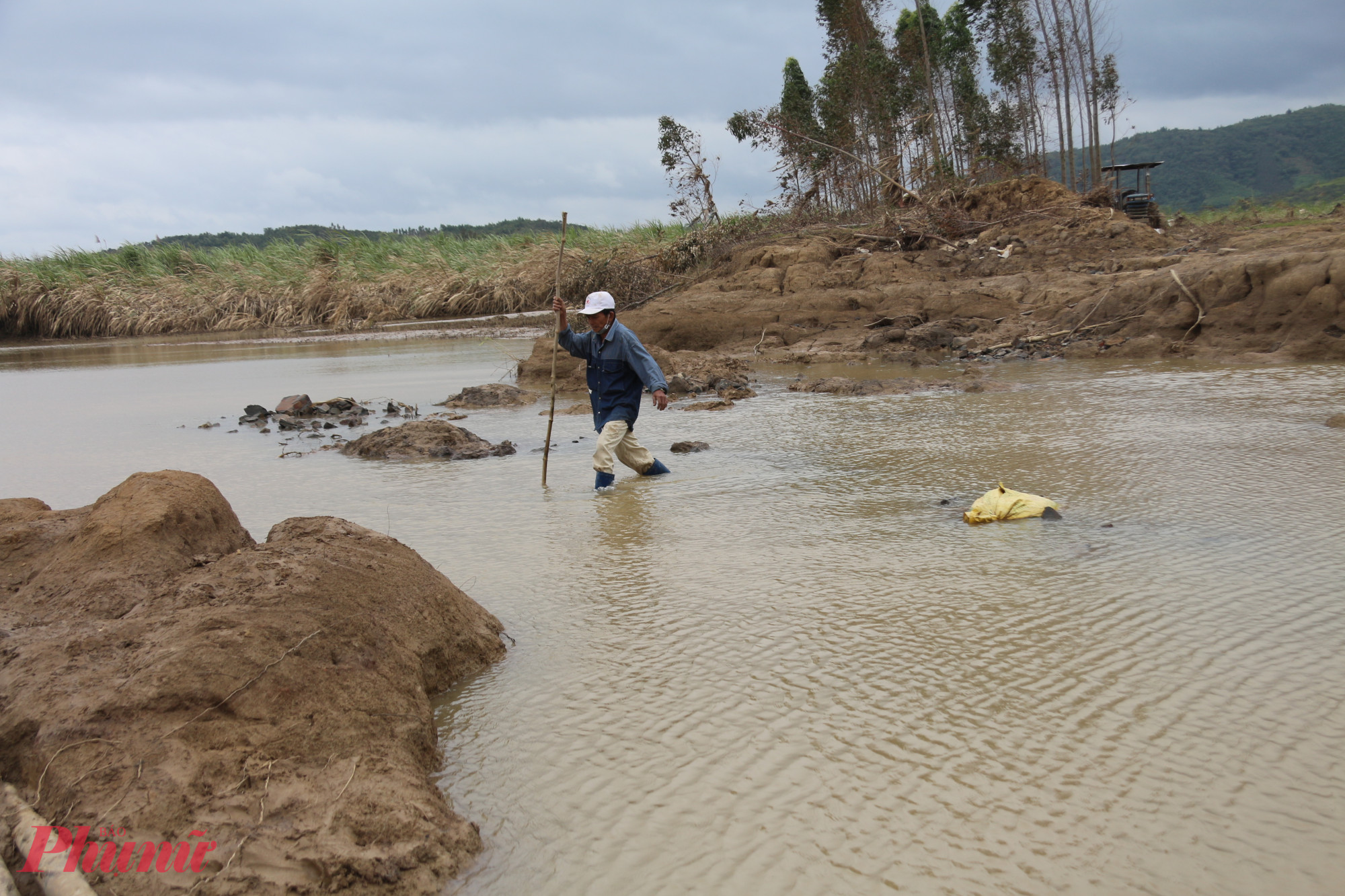 Do bùn đất dày đặc và trơn trượt nên người dân phải dùng cây rà đường để đi qua khu vực sạt lở