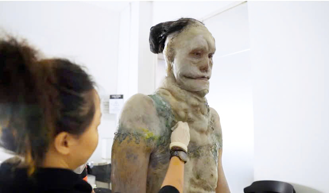 Chuyên gia hóa trang đang làm việc với vận động viên Trần Ngọc Tú để tạo hình nhân vật ma da trong phim Thám tử Kiên: Kỳ án không đầu - Ảnh do đoàn phim cung cấp