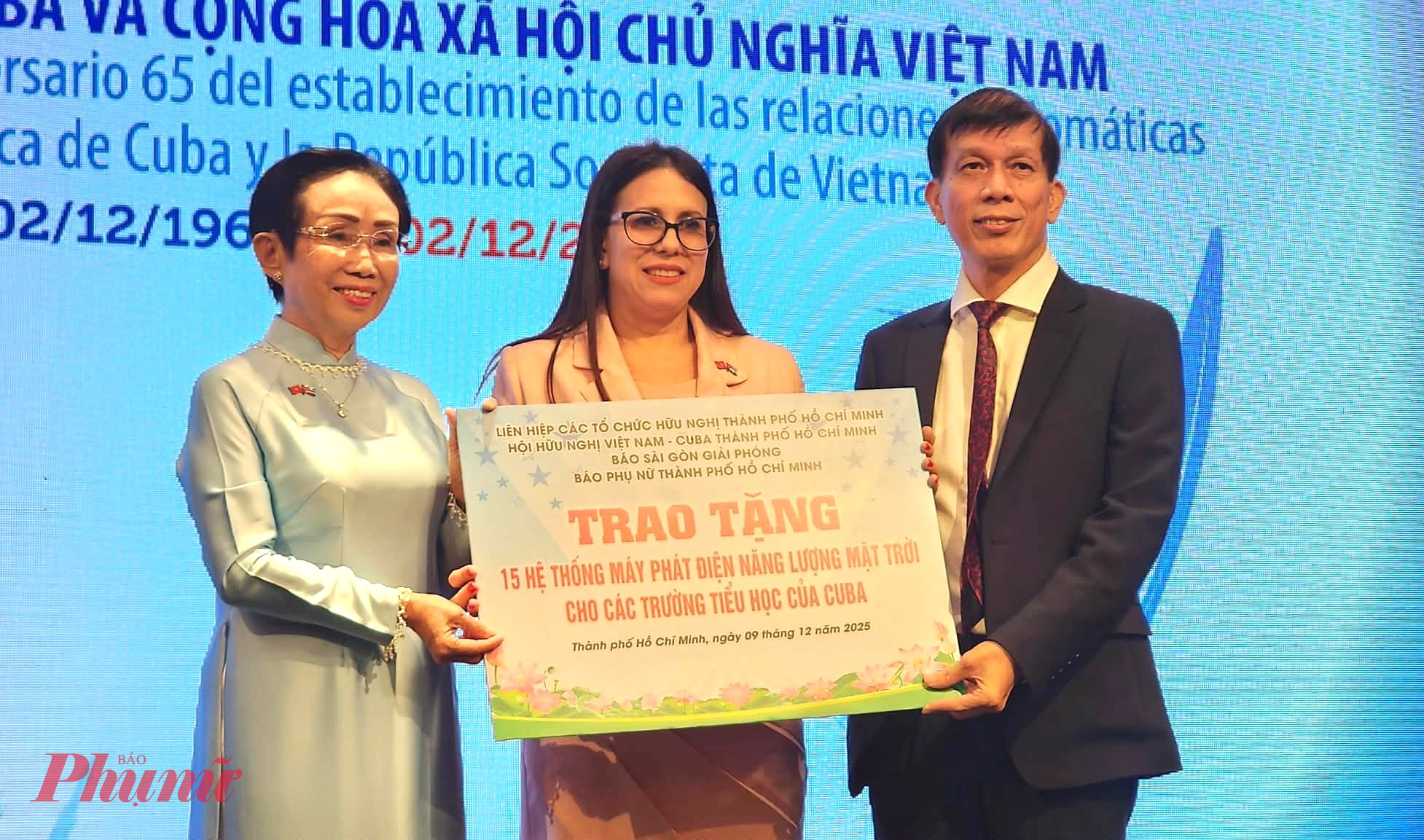 Bà Trương Thị Hiền – Chủ tịch Hội Hữu nghị Việt Nam – Cuba TP. Hồ Chí Minh (trái) và ông Nguyễn Khắc Văn – Quyền Tổng Biên tập Báo Sài Gòn Giải Phóng, đại diện Ban Tổ chức chiến dịch gây quỹ Mặt trời không biên giới trao bảng biểu trưng cho bà Ariadne Feo Labrada – Tổng Lãnh sự Cuba tại TPHCM