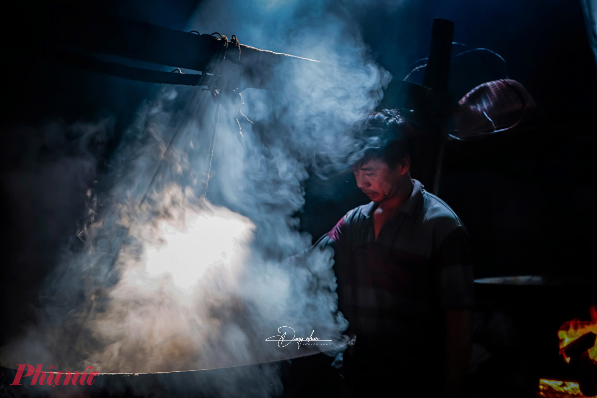 Trên bếp lửa đang cháy đỏ rực, hơi nước trắng xóa bốc lên dày đặc từ các nồi hấp khiến không gian mờ ảo như phủ sương. 