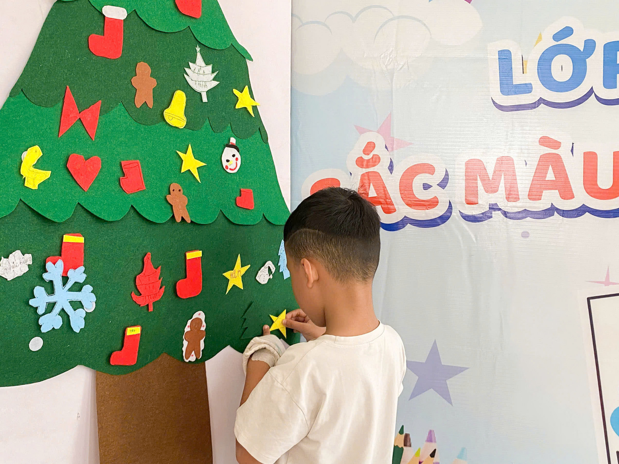 Những mẫu cắt dán đầy màu sắc được thực hiện bởi các em bệnh nhi, Sau khi hoàn thành, cây thông Noel sẽ được trưng bày tại khoa Nhi Tổng hợp trong suốt mùa giáng sinh 