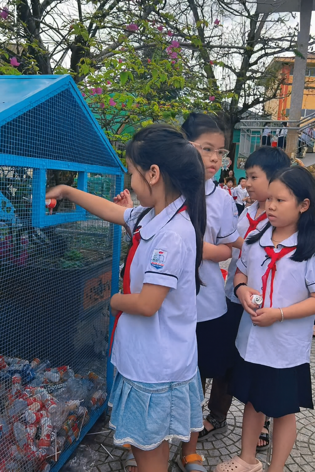 Các em học sinh thu gom rác và phân loại vào ngôi nhà xanh