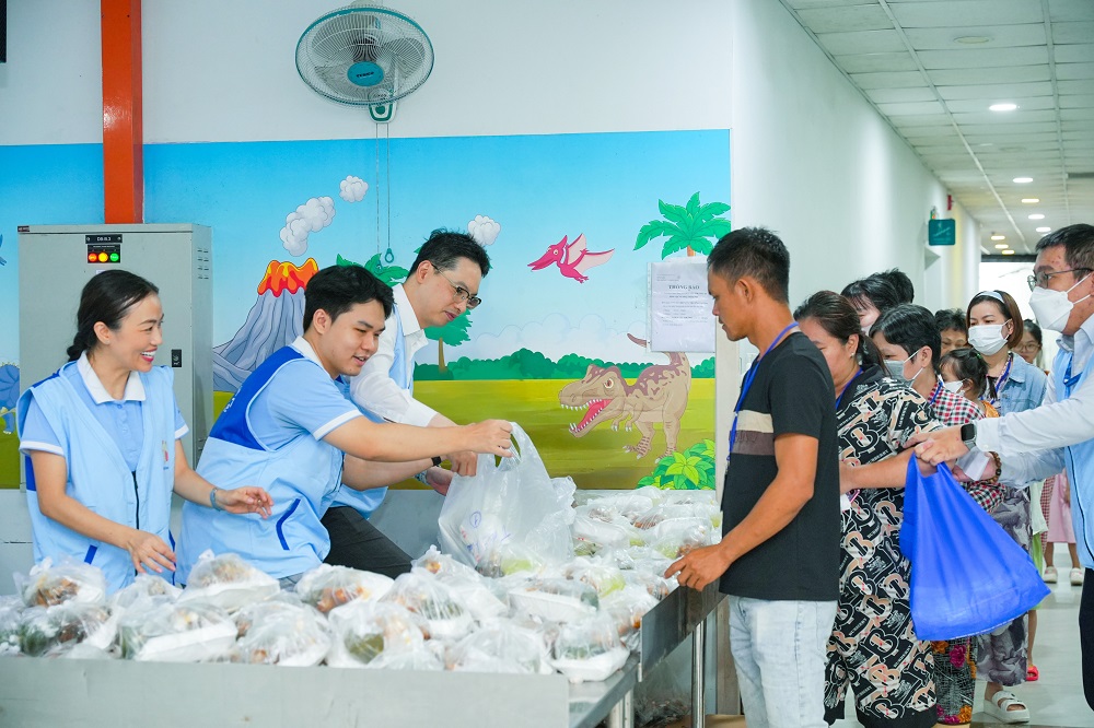 Hàng ngàn suất cơm trưa ấm áp cũng được trao tận tay đến người nhà bệnh nhi - Ảnh: Shinhan Life Việt Nam