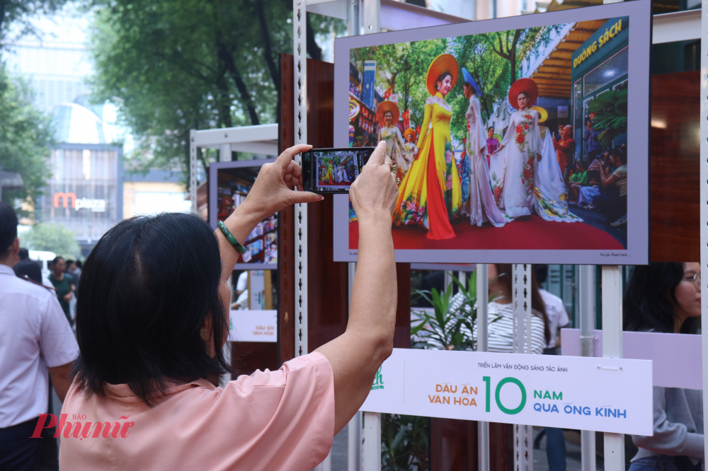 Khách tham quan nhanh chóng ghi lại các tác phẩm tại triển lãm diễn ra ở Đường Sách 