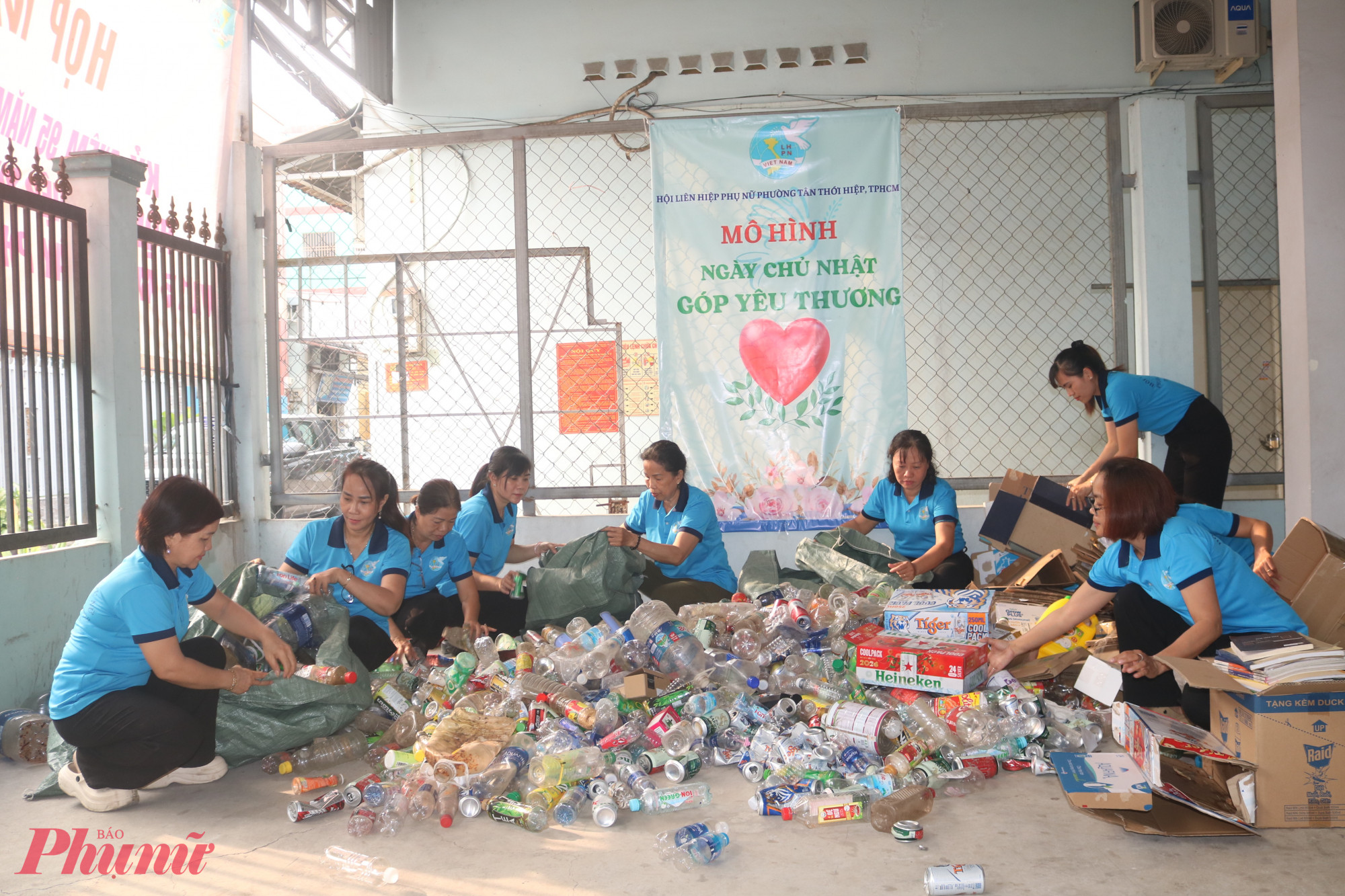 Chị em ở các chi hội thuộc cụm thi đua 14, phường Tân Thới Hiệp phân loại nguồn phế liệu vừa thu gom được - Ảnh: Mẫn Nhi