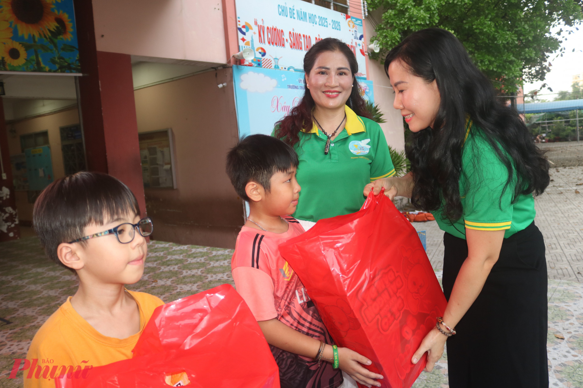 Bà Đặng Thị Kim Thoa – Phó chủ tịch Ủy ban MTTQ Việt Nam phường Trung Mỹ Tây, Chủ tịch Hội LHPN phường – trao quà đến các em học sinh - ảnh: Mẫn Nhi