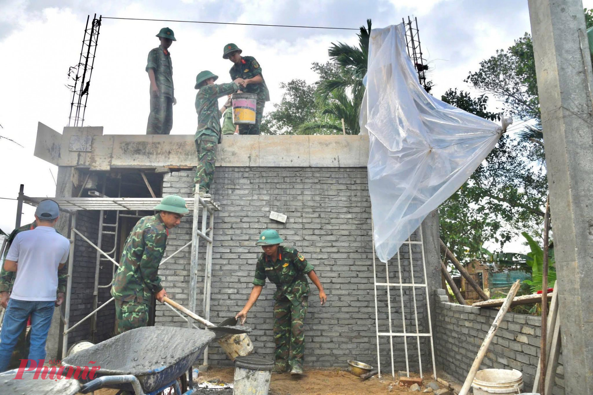  Từ sáng sớm đến tận tối muộn, từng tốp chiến sĩ tất bật xếp gạch, trộn hồ, đan sắt, xây từng bức tường…  với mong mỏi bà con sớm có chỗ che mưa nắng, kịp đón một cái Tết ấm áp sau những ngày hoạn nạn - Ảnh: P.L.