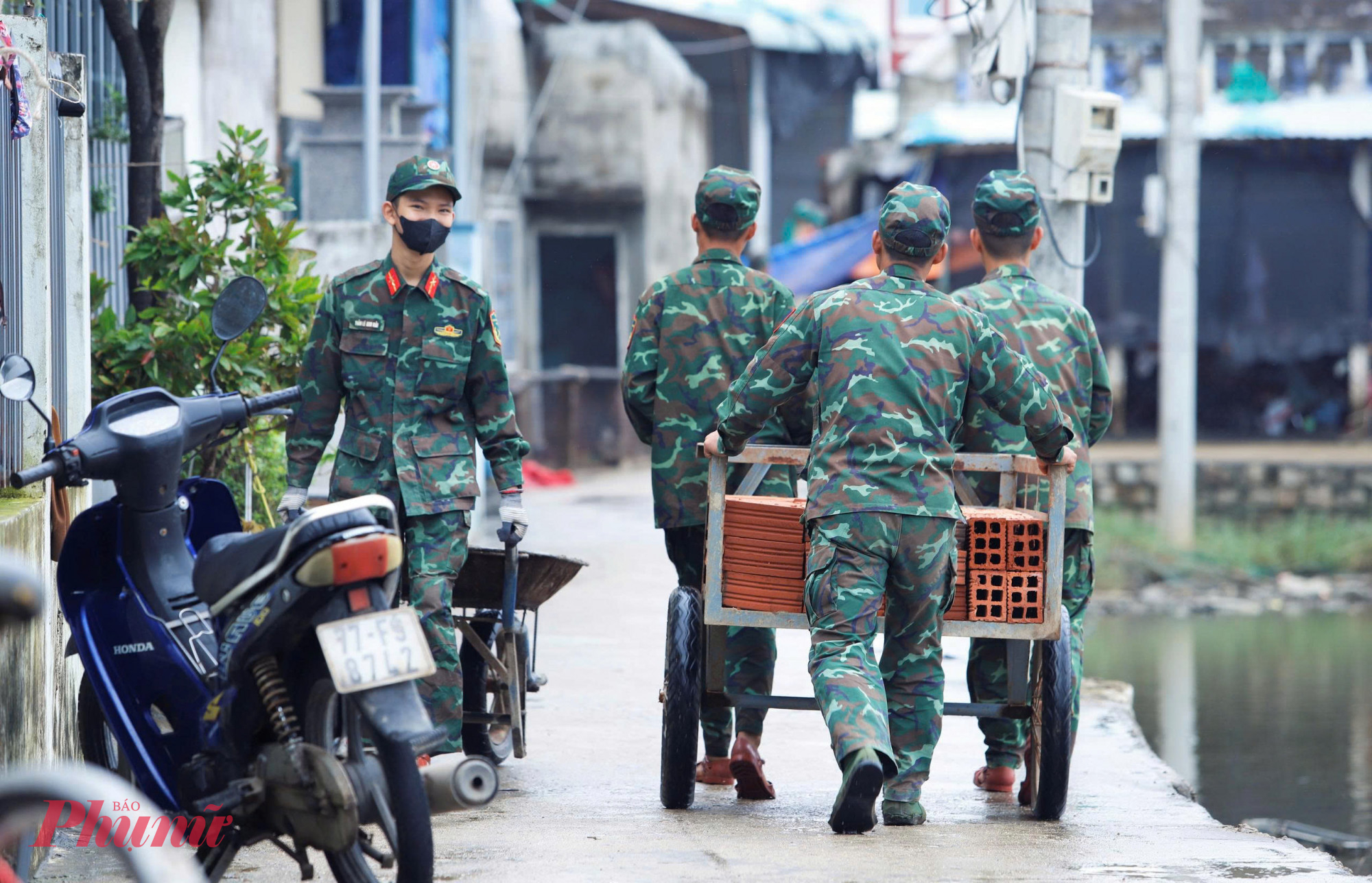  Một nhóm chiến sĩ miệt mài, tất bật vận chuyển từng viên gạch, bao vật liệu xây dựng