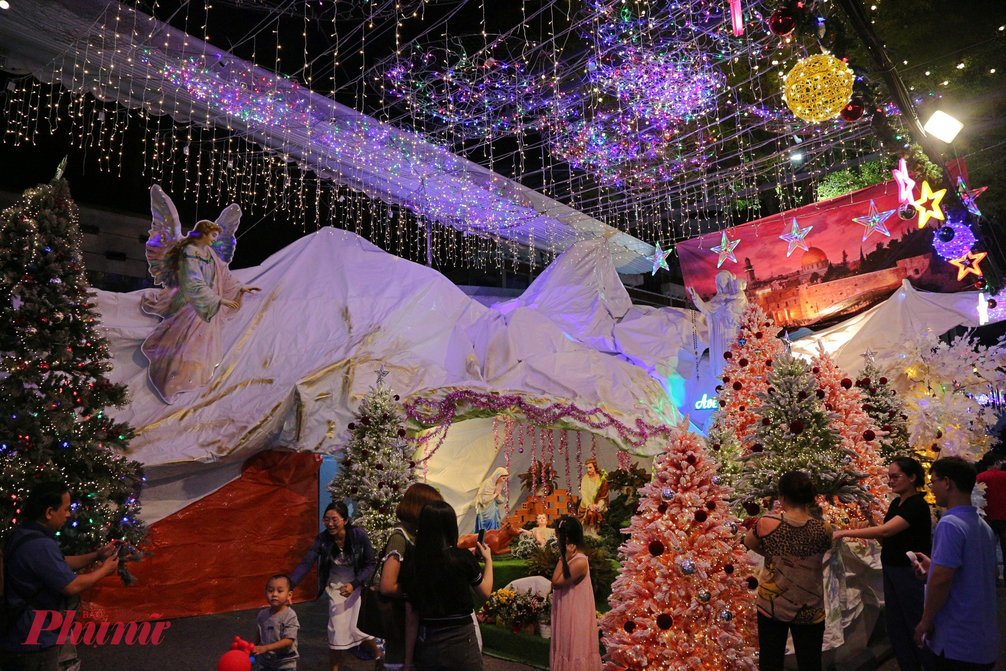 Tại một con hẻm trên đường Phạm Văn Chiêu vốn yên bình ngày thường, hàng trăm mét đèn LED được giăng kín, tạo thành những vòm sáng lung linh. Ánh đèn vàng ấm xen lẫn sắc đỏ, xanh, trắng khiến cả không gian như bước ra từ một câu chuyện cổ tích.