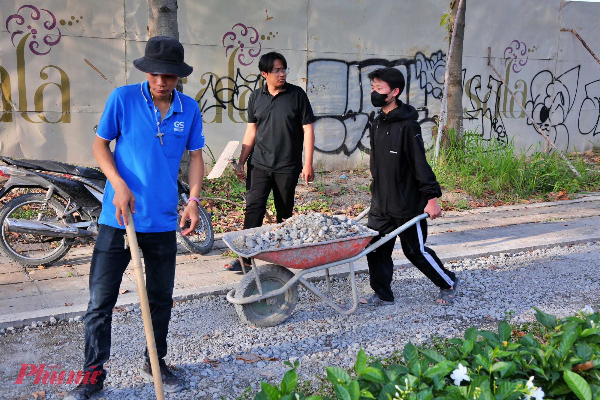 Công nhân đang đổ đá, san lấp mặt đường trước khi tiến hành đổ thảm nhựa