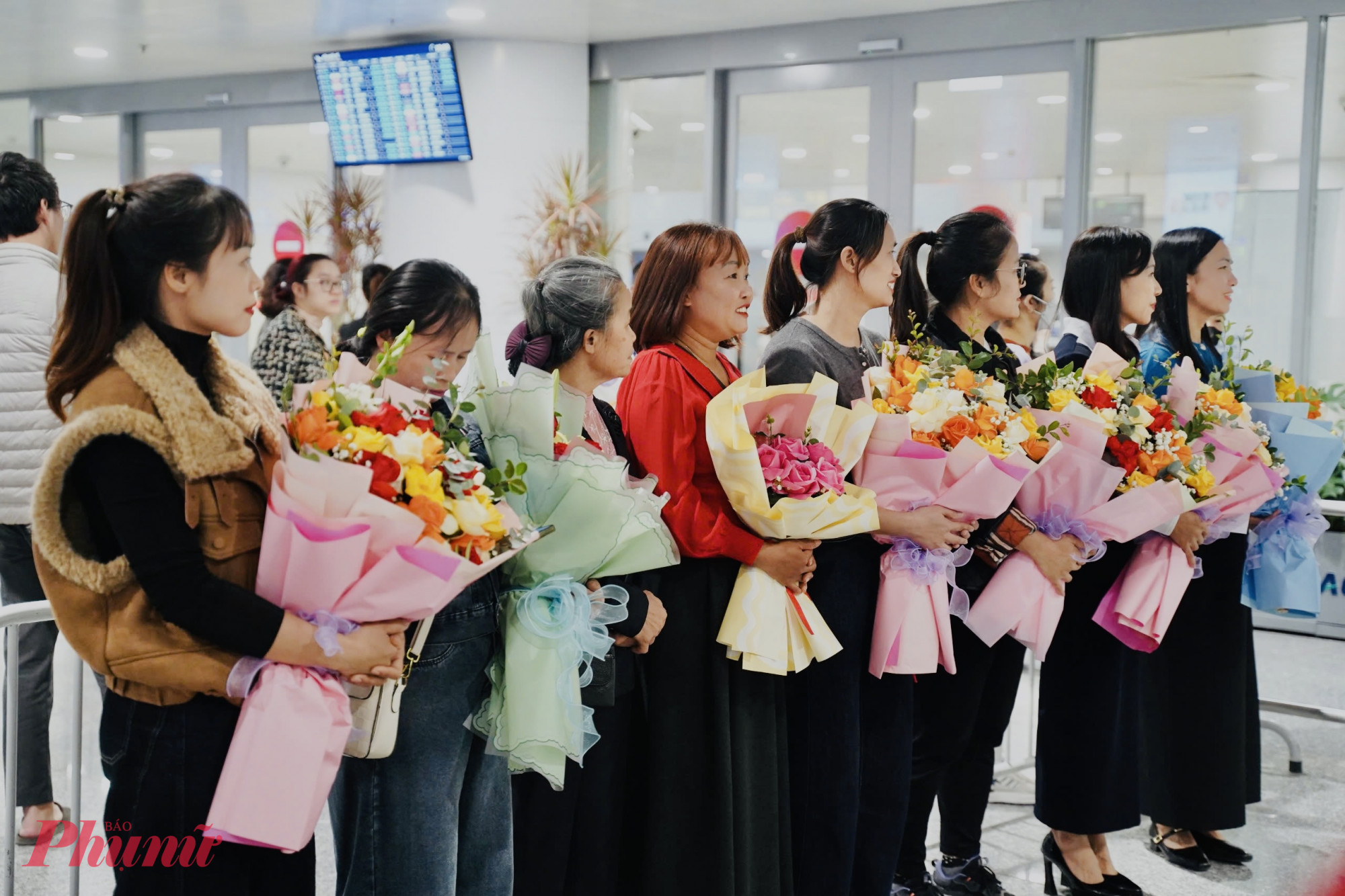 Người thân với những bó hoa chờ đón các vận động viên tại sân bay Nội Bài.