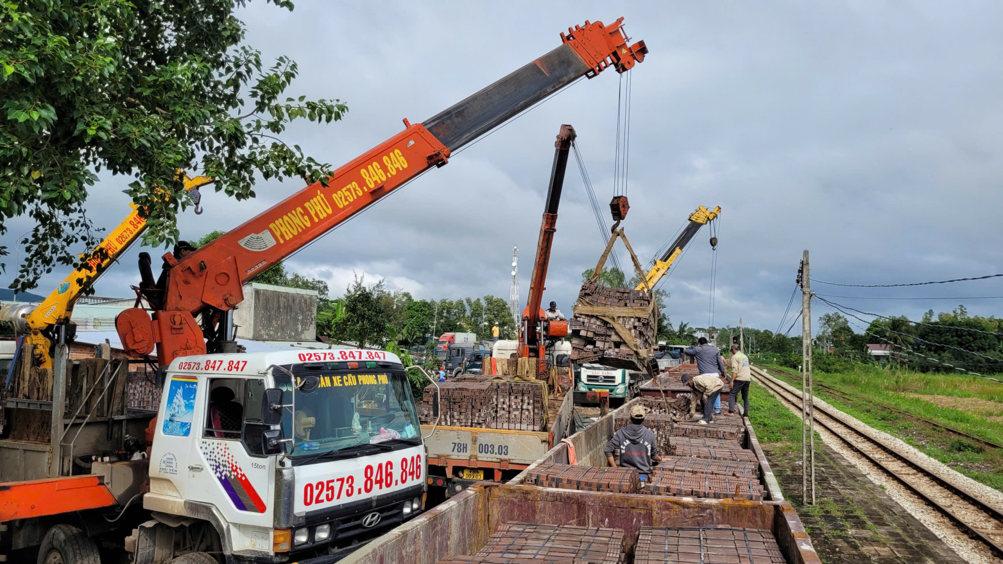 Bốc dỡ gạch từ các toa tàu hàng tại ga Hòa Đa xuống các xe tải, sau đó phân phối cho các nhà thầu thi công-Ảnh: H. Như