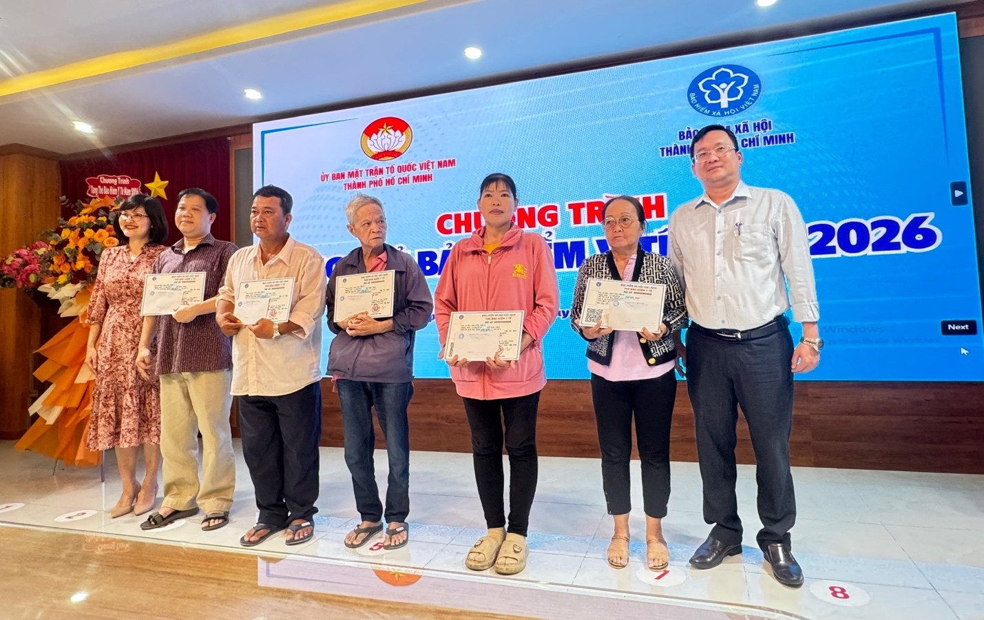 Ông Phan Hồng Ân - Phó chủ tịch Ủy ban MTTQ Việt Nam TPHCM (ngoài cùng bên phải) cùng nhà tài trợ trao thẻ cho người dân