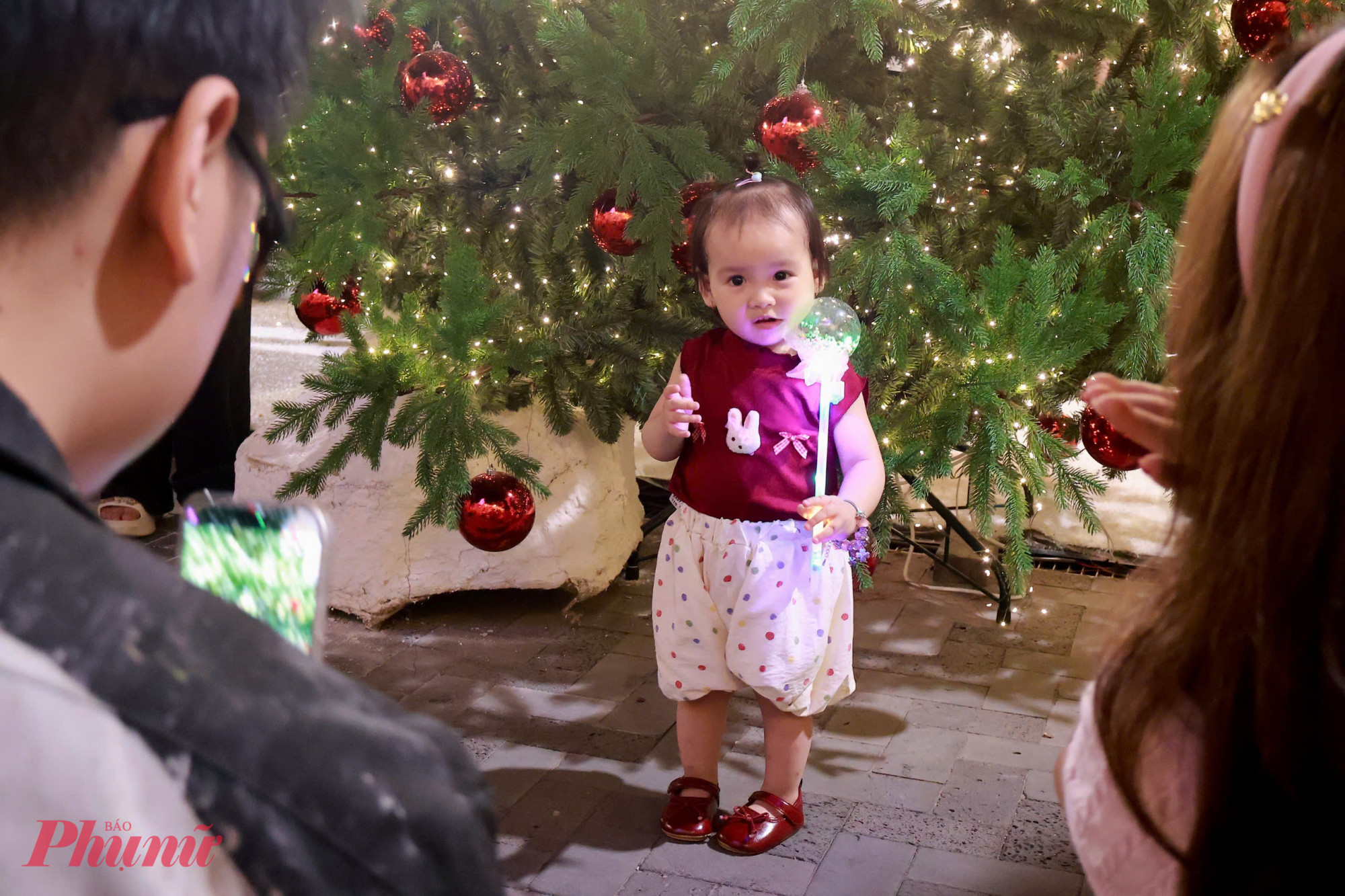 Gia đình trẻ ghi lại khoảnh khắc sum vầy bên cây thông Giáng sinh.