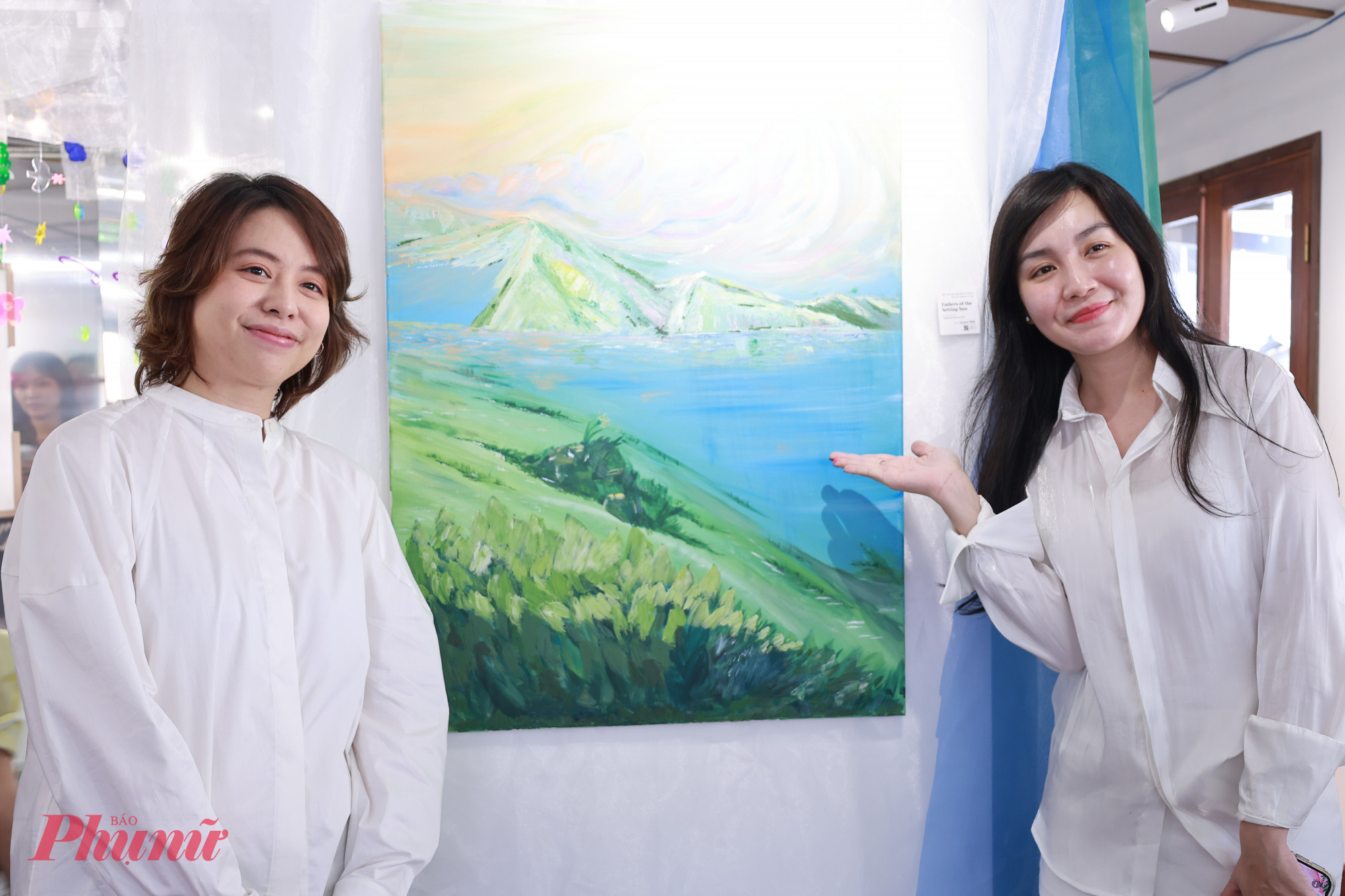 Nữ hoạ sĩ (trái) chụp ảnh cùng khách thưởng lãm 