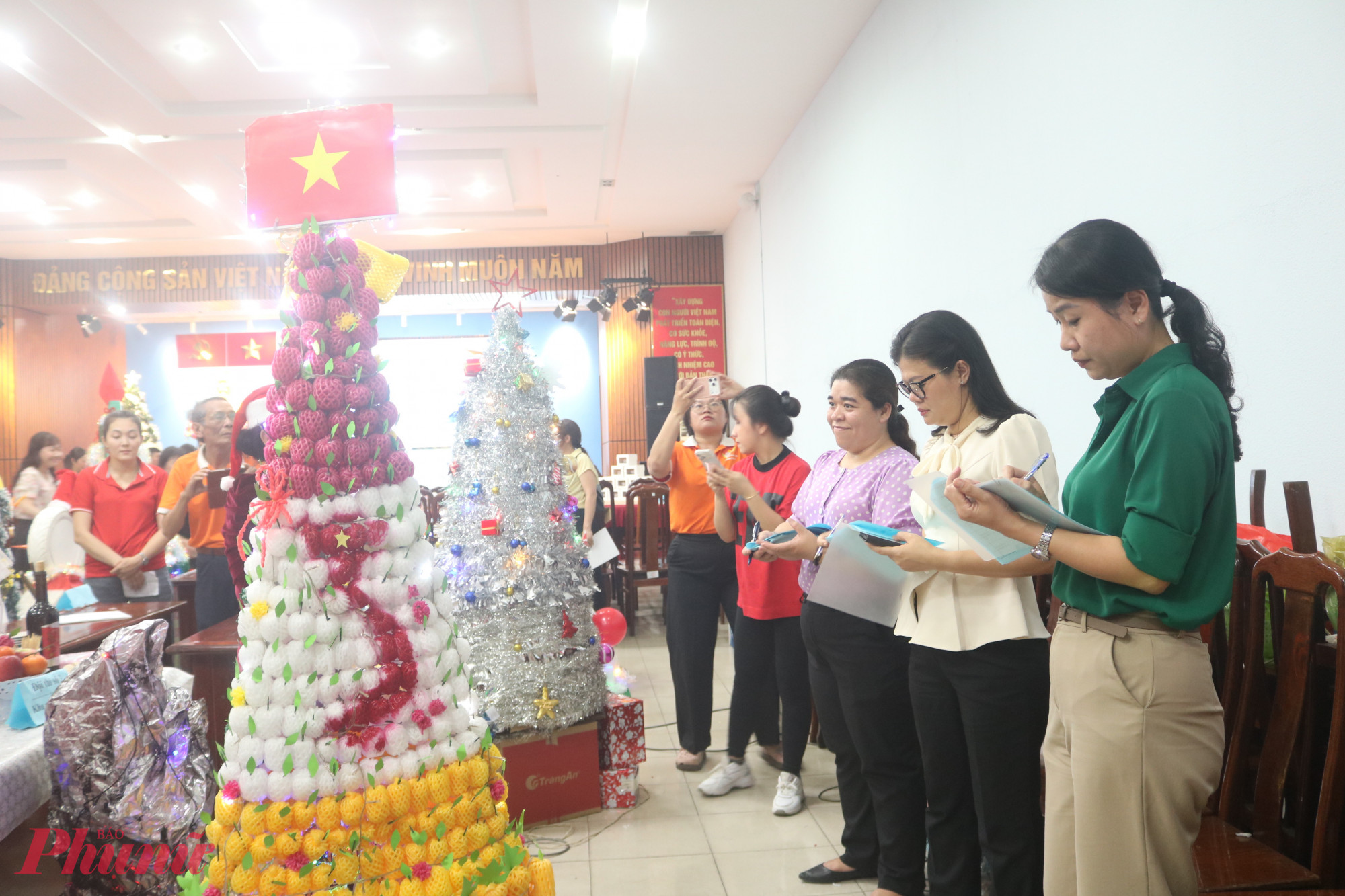 Ban giám khảo chấm điểm các cây thông Giáng sinh và người tuyết từ vật liệu tái chế - Ảnh: Mẫn Nhi