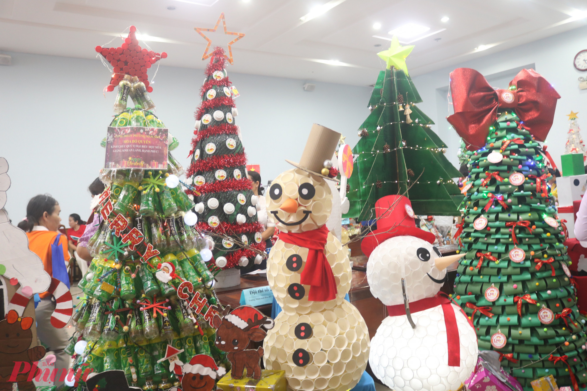 Phần thi thiết kế, trang trí cây thông Giáng sinh và người tuyết từ vật liệu tái chế thu được 25 cây thông Giáng sinh và 25 người tuyết vô cùng độc đáo. Các đội thi đã tận dụng giấy báo cũ, ly giấy, vỏ lon nước ngọt, mút xốp, bìa cứng… để tạo hình sản phẩm dự thi vừa đẹp mắt vừa có thể dùng trang trí tại nhà, văn phòng khu phố trong mùa Giáng sinh. Trường mầm non Hoàng Yến đoạt giải nhất hội thi này - Ảnh: Mẫn Nhi