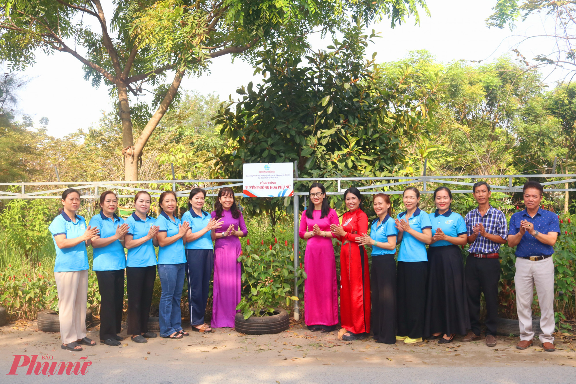 Các chị em cùng gỡ bảng công trình “Tuyến đường hoa phụ nữ” tại đường Thạnh Xuân 14 - Ảnh: Mẫn Nhi