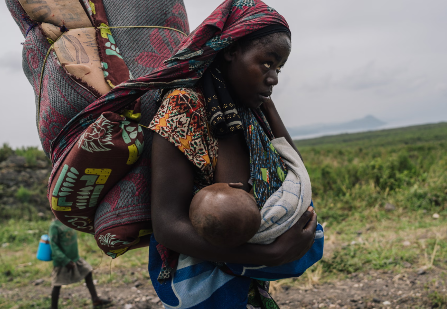 Một thường dân di tản với một em bé đi bộ về ngôi làng quê hương của cô ở Goma ở Cộng hòa Dân chủ Congo. Ảnh: Hugh Kinsella Cunningham / Getty Images