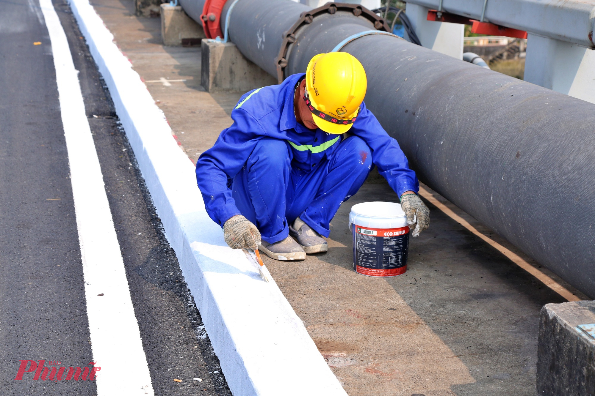 Công nhân đang hoàn thiện vạch kẻ đường, lề đường.