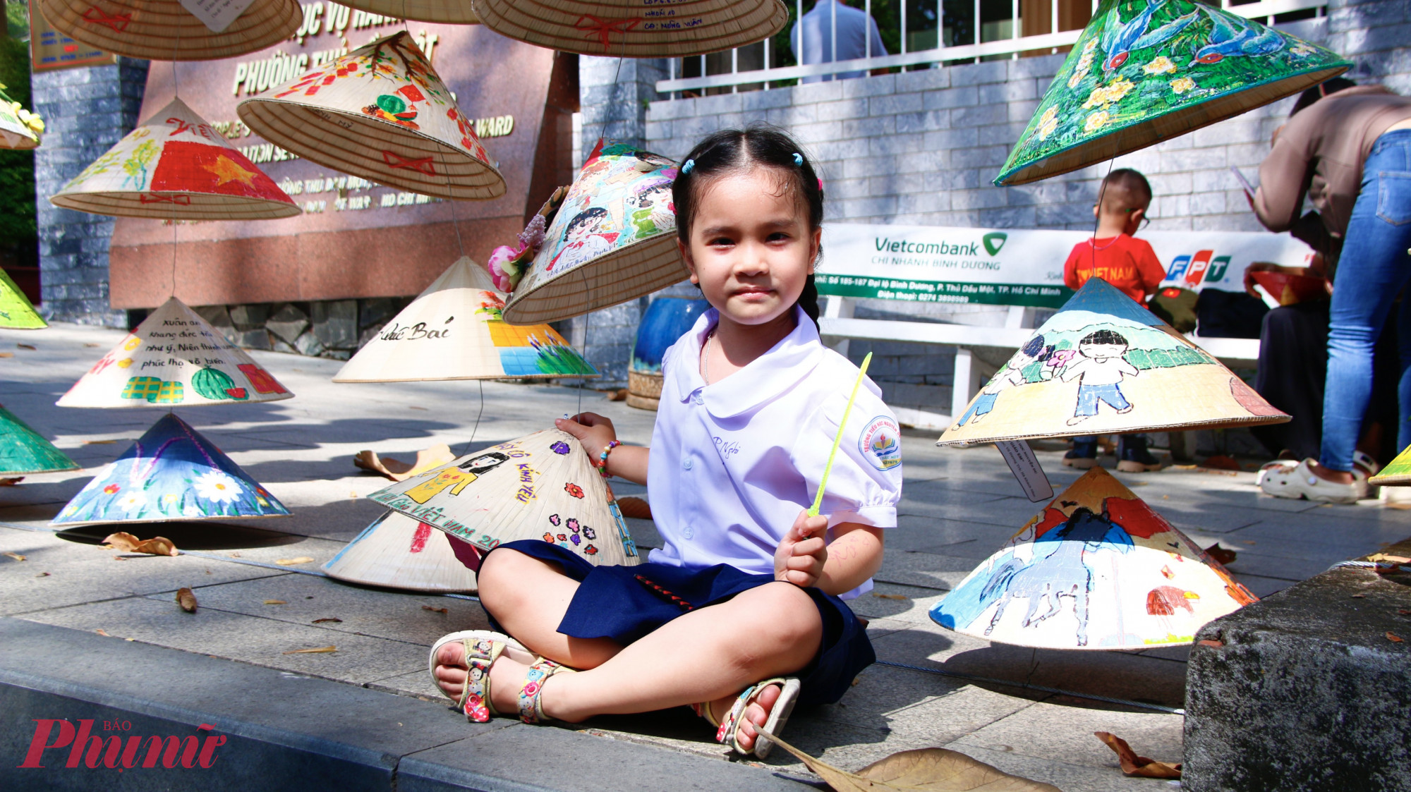 Bé Nguyễn Trần Phương Nghi, học sinh lớp 1/3, Trường Tiểu học Nguyễn Du, thích thú ngắm nghía tác phẩm do mình và các bạn trong lớp tham gia dự thi được trưng bày trên tuyến đường Quang Trung.