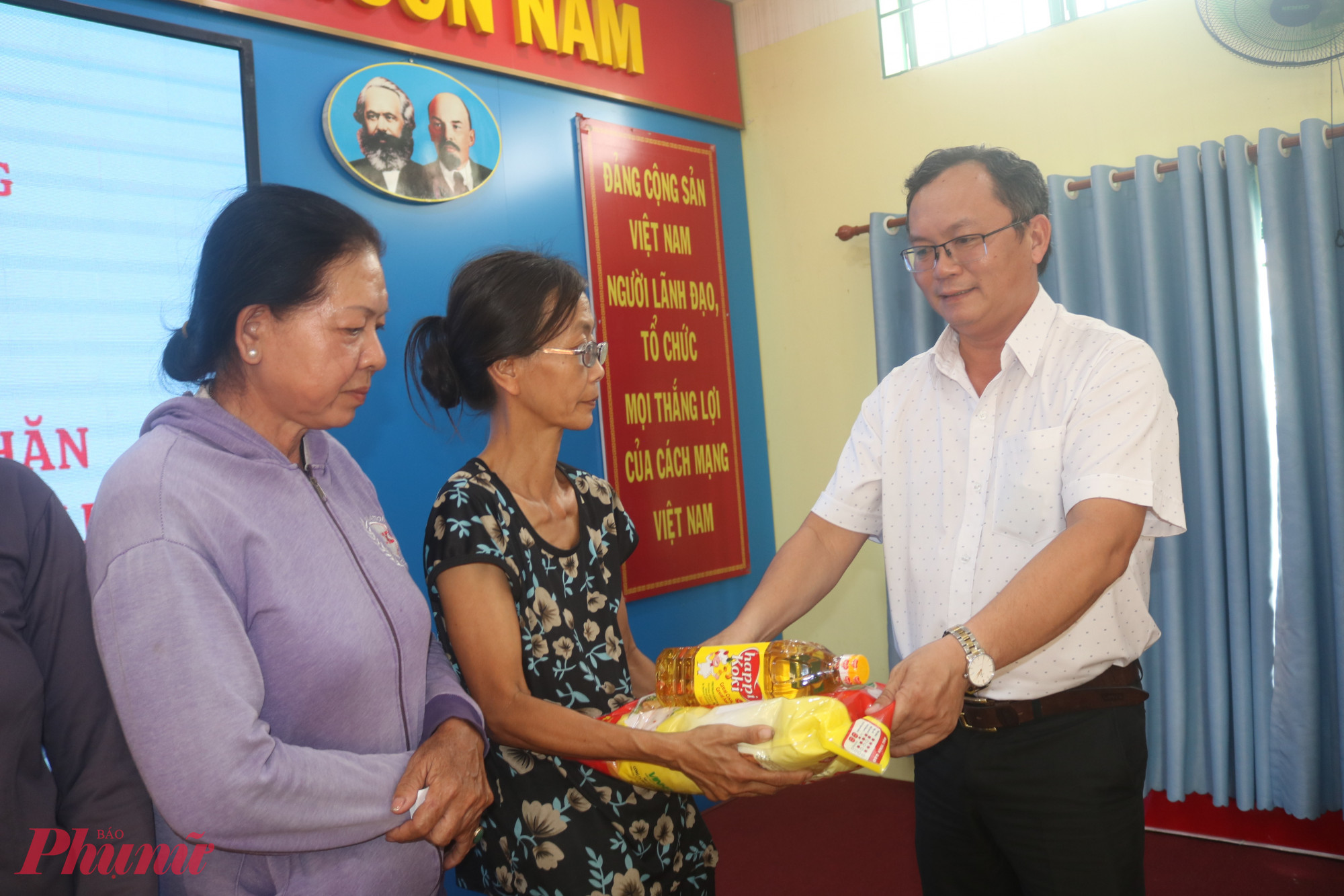 Ông Nguyễn Ngọc Toàn – Phó chủ tịch UBND phường Bình Trị Đông – trao quà đến đại diện các hộ dân - Ảnh: Mẫn Nhi 